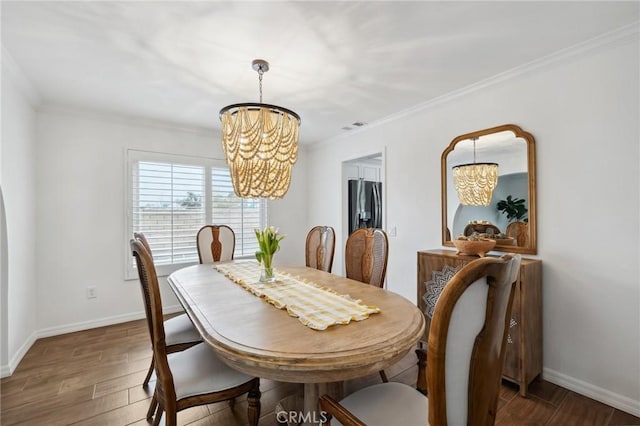 dining room with baseboards, a chandelier, wood finished floors, and ornamental molding