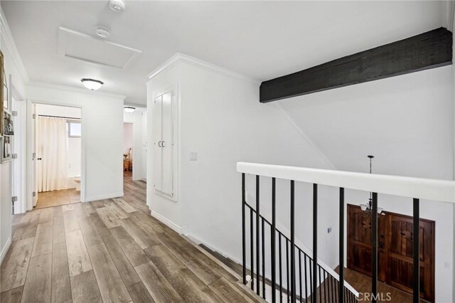 hall with crown molding, attic access, wood finished floors, beamed ceiling, and baseboards