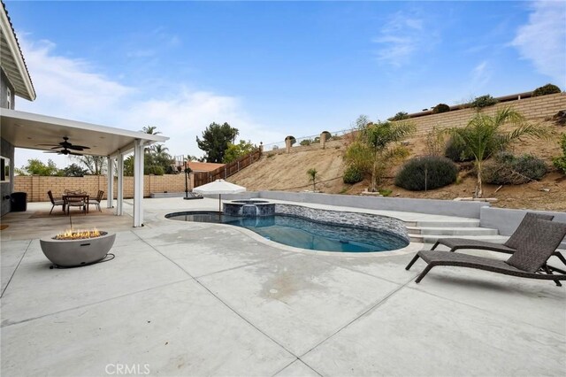 view of pool with an outdoor fire pit, a patio area, a fenced backyard, and ceiling fan