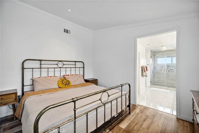 bedroom with ornamental molding, visible vents, and wood finished floors