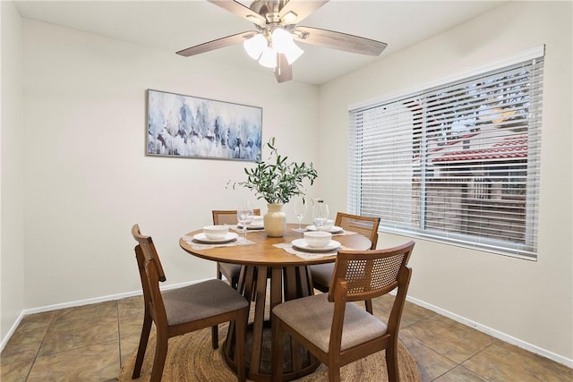 dining area with ceiling fan, baseboards, and tile patterned floors