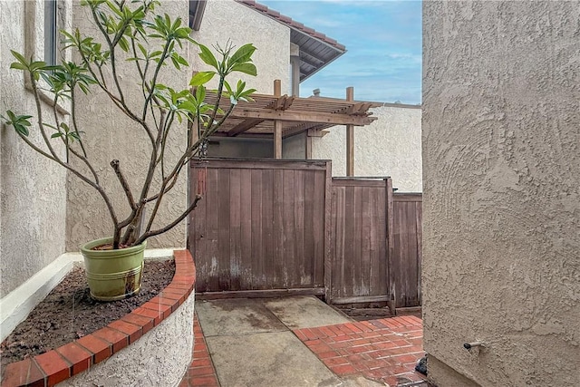 exterior space featuring a pergola, a tile roof, fence, and stucco siding