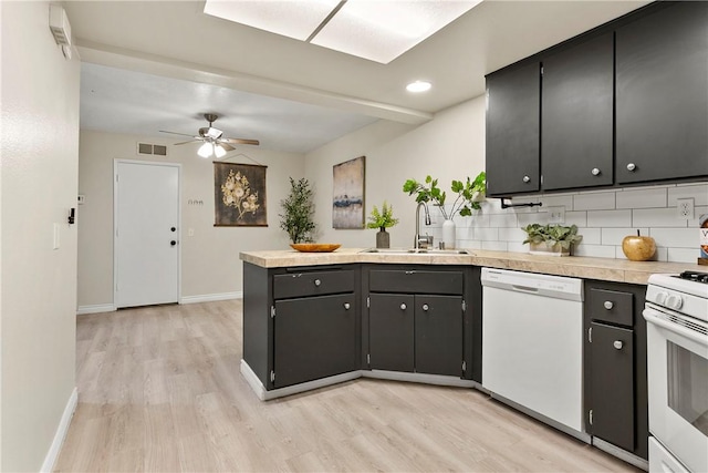 kitchen with light wood finished floors, visible vents, a sink, white appliances, and a peninsula