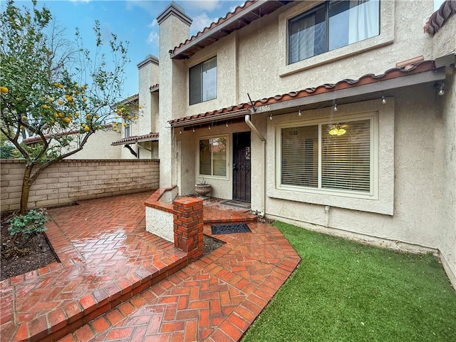 back of property featuring a tile roof, a patio, and stucco siding