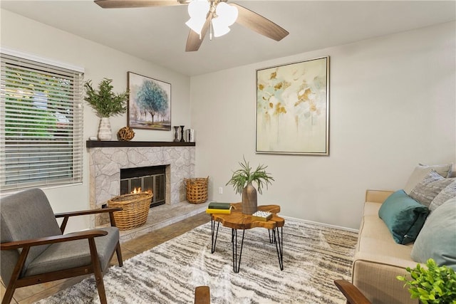 living area with tile patterned flooring, a fireplace, and ceiling fan