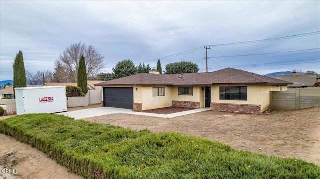 single story home with driveway, stucco siding, fence, and brick siding