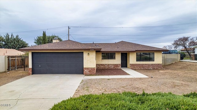 single story home featuring a garage, driveway, brick siding, fence, and stucco siding