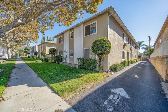 view of home's exterior featuring a yard, a residential view, and stucco siding