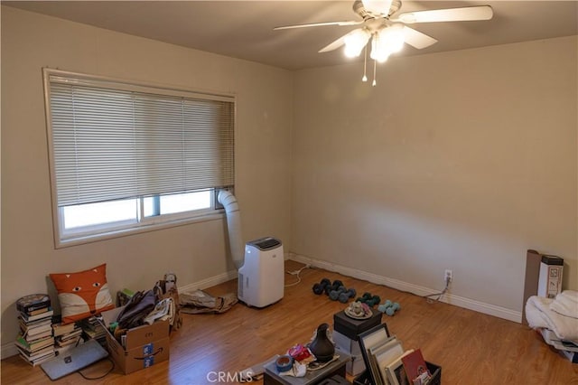 unfurnished room featuring ceiling fan, baseboards, and wood finished floors