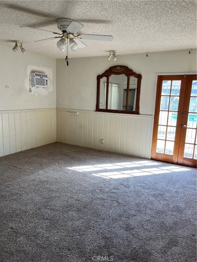 2609 E Cortez St, West Covina, CA 91791 - carpeted spare room featuring french doors, an AC wall unit, a textured ceiling, wainscoting, and ceiling fan