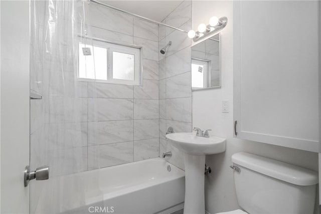 bathroom featuring bathtub / shower combination and toilet