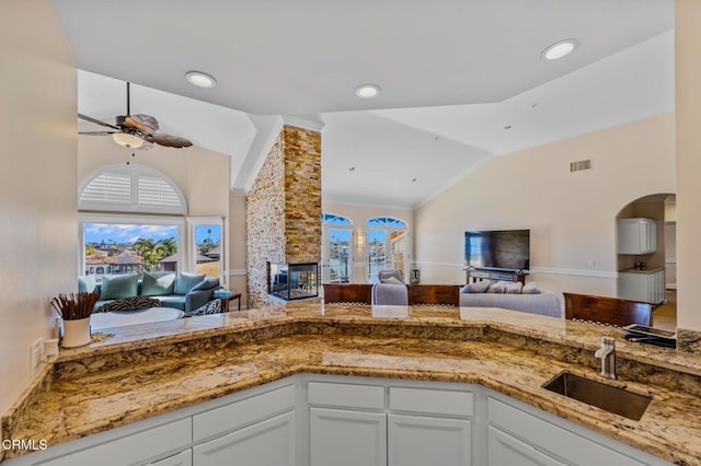 kitchen featuring a sink, visible vents, open floor plan, and vaulted ceiling