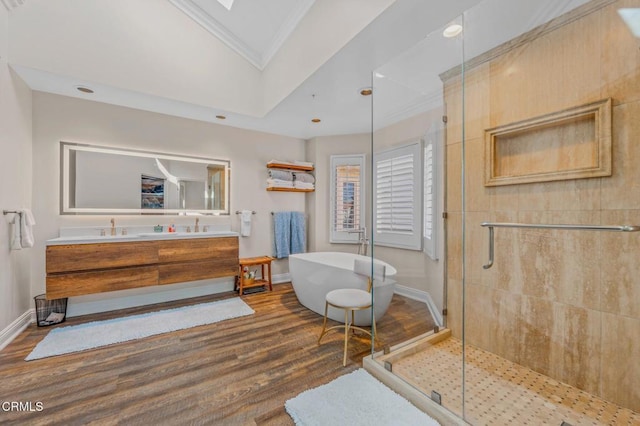 full bath featuring a shower stall, a freestanding bath, ornamental molding, a skylight, and wood finished floors