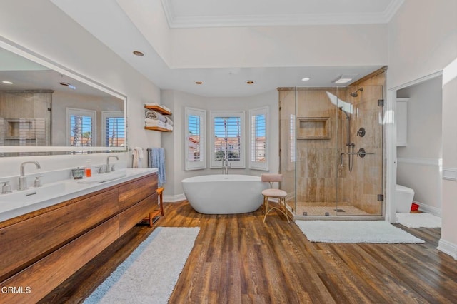 bathroom with wood finished floors, a soaking tub, a stall shower, and crown molding