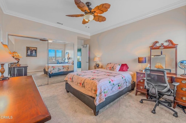 carpeted bedroom with baseboards, visible vents, ceiling fan, ornamental molding, and a closet