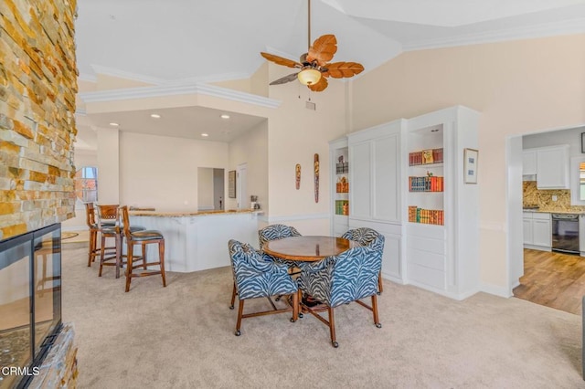 dining room featuring wine cooler, light carpet, high vaulted ceiling, and a stone fireplace