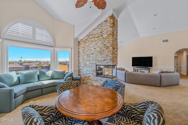 carpeted living area with visible vents, arched walkways, high vaulted ceiling, and a ceiling fan