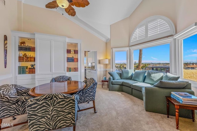 carpeted living room featuring ceiling fan and high vaulted ceiling