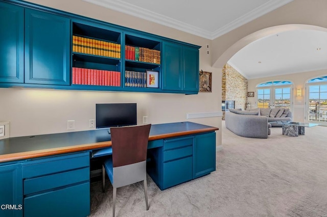 office featuring lofted ceiling, arched walkways, ornamental molding, built in desk, and light colored carpet