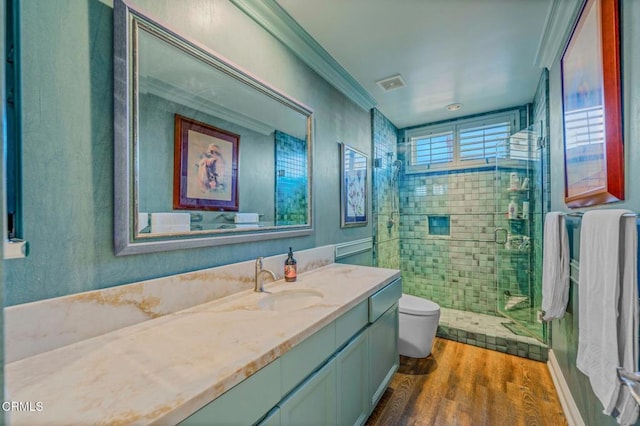 bathroom with visible vents, toilet, a stall shower, wood finished floors, and vanity