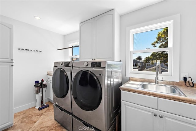 laundry room featuring recessed lighting, cabinet space, a sink, washer and dryer, and baseboards