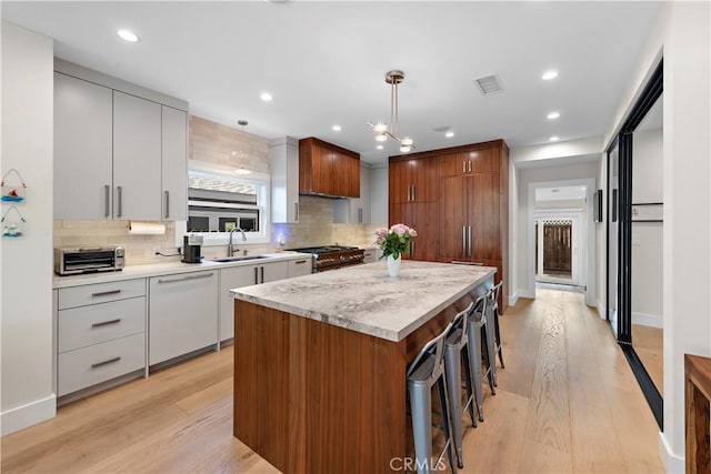 kitchen with dishwasher, modern cabinets, a breakfast bar area, a center island, and high end stainless steel range oven