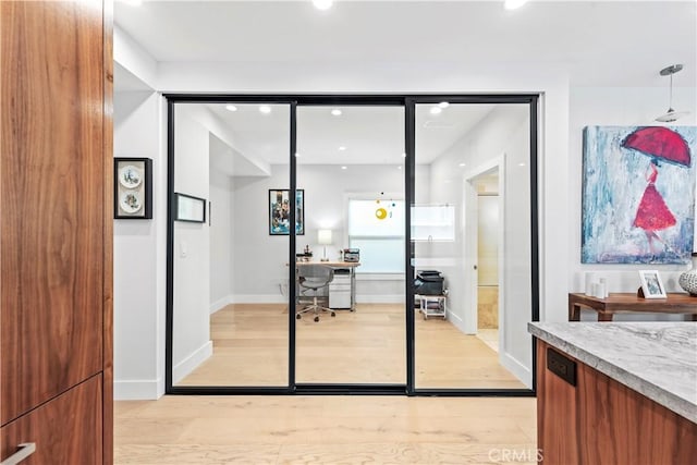 wine area featuring light wood-style floors and baseboards