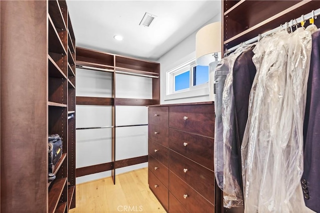 walk in closet with light wood-type flooring and visible vents