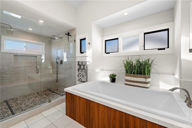 full bath featuring a stall shower, tile patterned flooring, and a bath