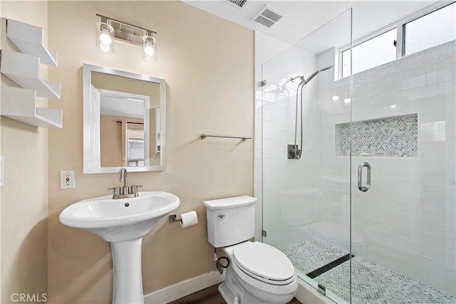 full bath with toilet, a sink, visible vents, baseboards, and a shower stall