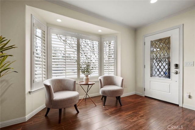 sitting room featuring ornamental molding, baseboards, and wood finished floors