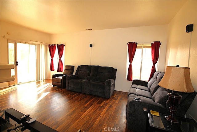 living room with hardwood / wood-style flooring, plenty of natural light, and visible vents