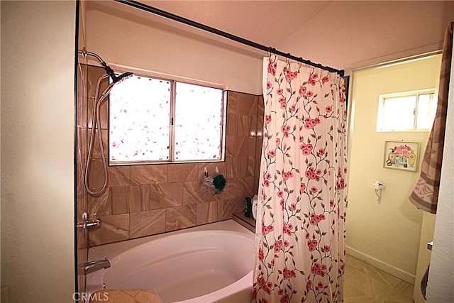 full bathroom featuring shower / bath combination with curtain and baseboards