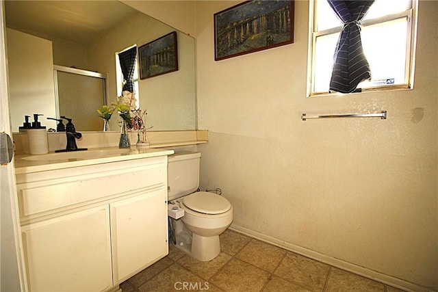 full bath featuring toilet, vanity, baseboards, tile patterned floors, and a stall shower