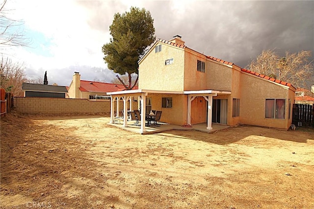 rear view of property with a fenced backyard, a patio, and stucco siding