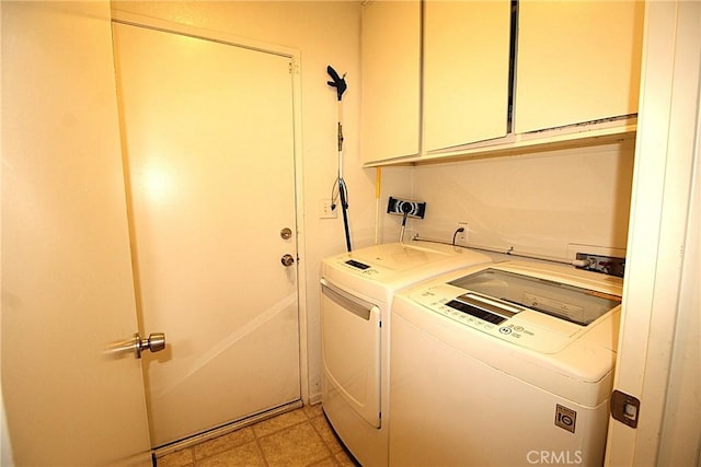 clothes washing area featuring washing machine and dryer and cabinet space