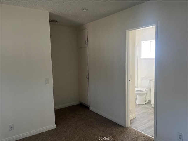 unfurnished room with carpet, a textured ceiling, and baseboards