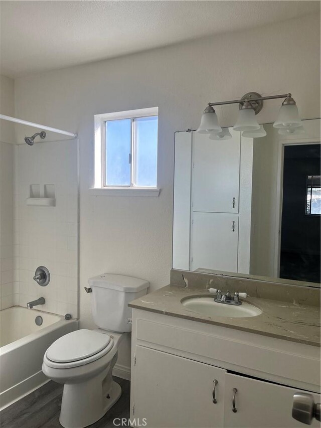 bathroom with tub / shower combination, vanity, toilet, and wood finished floors