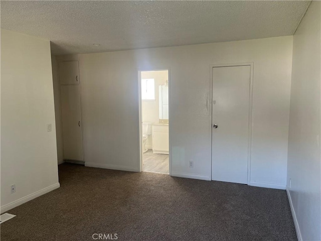 unfurnished room featuring a textured ceiling, carpet, visible vents, and baseboards