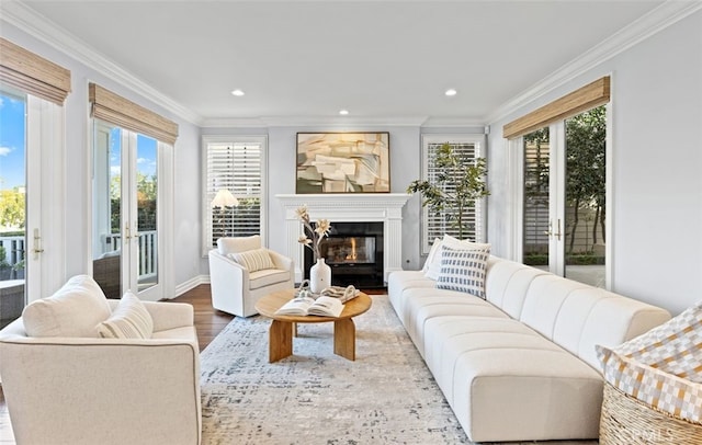 living room featuring ornamental molding, a glass covered fireplace, recessed lighting, and wood finished floors