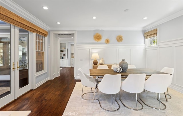 dining area featuring visible vents, ornamental molding, hardwood / wood-style floors, a decorative wall, and recessed lighting