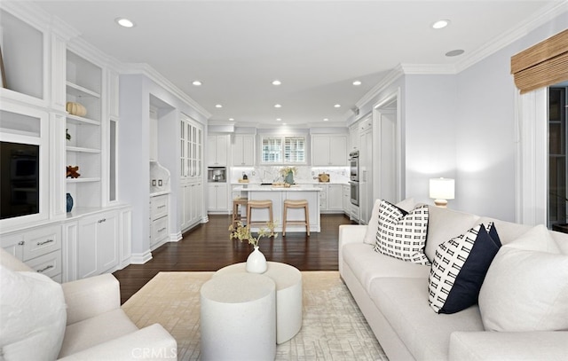 living area with ornamental molding, dark wood finished floors, and recessed lighting