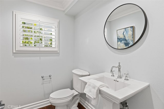 bathroom featuring ornamental molding, a sink, toilet, and baseboards