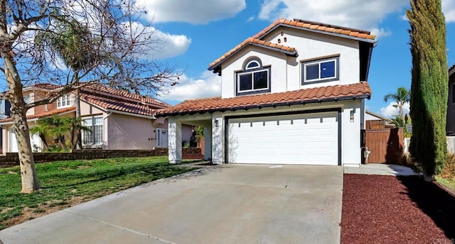 mediterranean / spanish house with a garage, concrete driveway, a tiled roof, stucco siding, and a front lawn