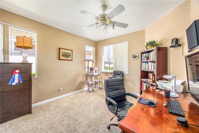 home office with a ceiling fan, carpet flooring, and baseboards