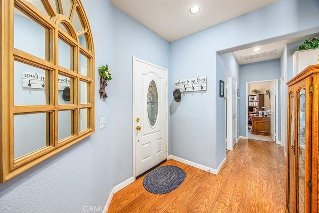 foyer featuring light wood-type flooring, visible vents, baseboards, and recessed lighting