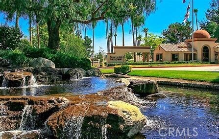 surrounding community with a water view and a lawn