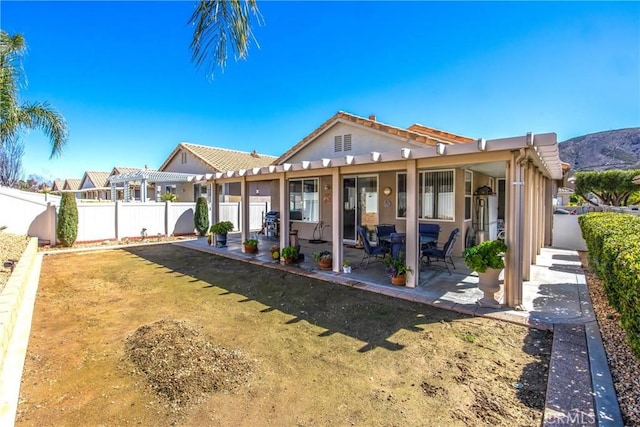 5855 Myrtle Beach Dr, Banning, CA 92220 - rear view of house with a fenced backyard, a patio area, stucco siding, and a pergola