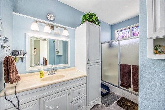 full bath featuring a stall shower, tile patterned flooring, and vanity