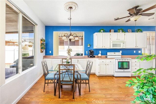 kitchen featuring decorative light fixtures, white appliances, white cabinets, and light wood-style flooring